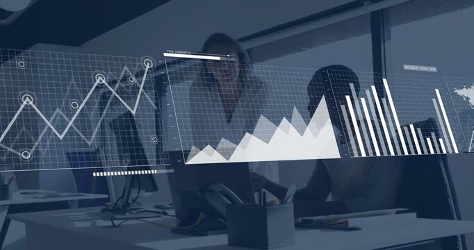 Standing woman pointing, seated woman using laptop, initiating business charts and world map review