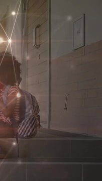 Vertical video: Pupil sitting steps adjusting striped bag waiting star overlay sweeping on play