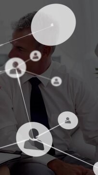Vertical video: Mgr seated listening, woman gesturing sparking network mapping biz ties on frame