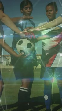Vertical video: Ball holder initiating hand stack on ball female soccer players building team unity
