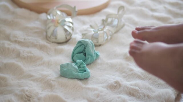 Child Bare Feet Wiggling on a Fluffy White Rug with Socks and Sandals