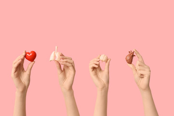 Female hands with human internal organ models on pink background © Pixel-Shot