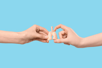 Fototapeta premium Female hands with human lungs model on blue background