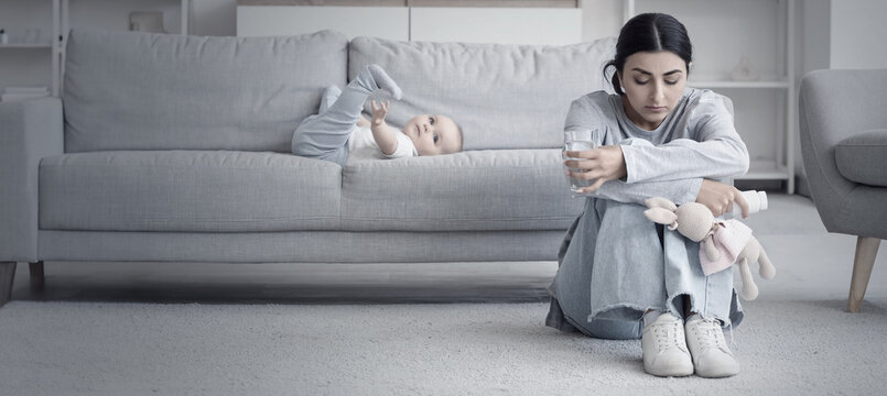 Little baby and young mother suffering from postnatal depression at home