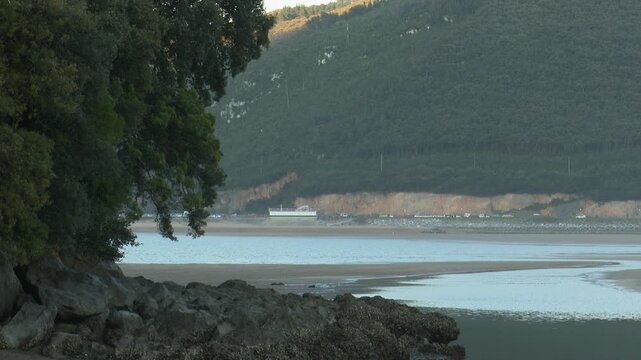 Scenic view of Urdaibai wetland in Bizkaia, a biosphere reserve and key migratory bird habitat. Natural marsh landscape with tidal waters, vegetation, and peaceful environmental biodiversity.