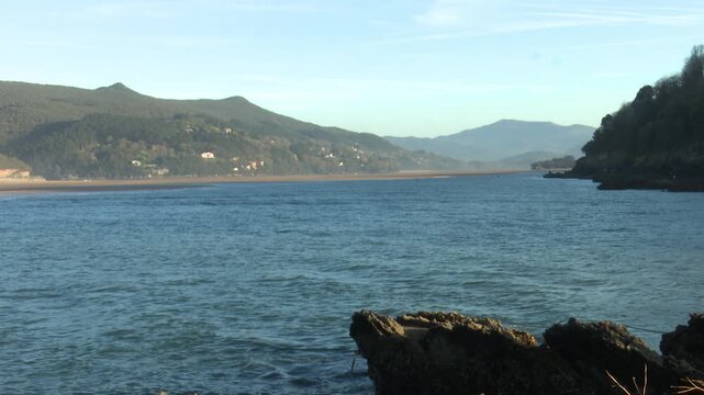 Scenic view of Mundaka on the Cantabrian coast in Bizkaia, famous worldwide for its powerful left-hand surf wave. Coastal town landscape with ocean swell, harbor, and natural surroundings.