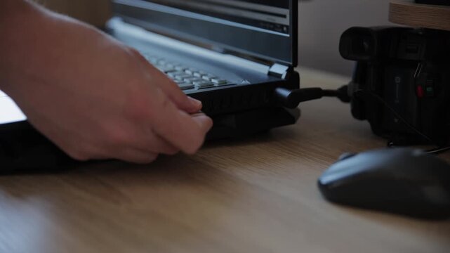 Man Inserting USB Flash Drive into Laptop Computer Port Close-up