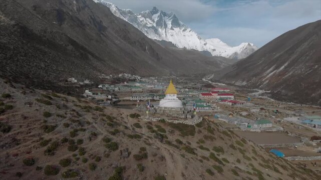 Aerial drone view of Dingboche village with a white Buddhist stupa and snow-capped peaks in the background