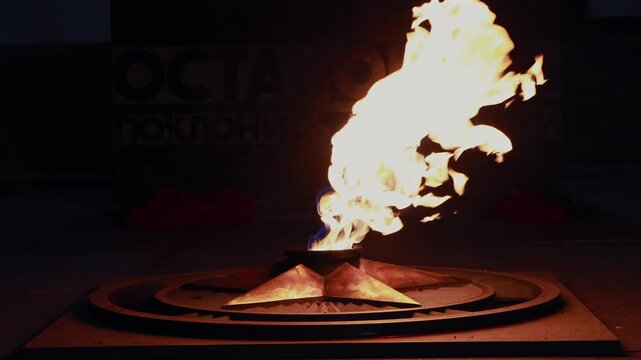 Glowing fire of eternal flame burning from bronze star monument