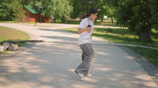 shaded park path streetstyle dancer posing with cap and sunglasses confident male steps through sundappled pavement, directs arms, executes crisp grooves near bench and backpack, contemporary urban