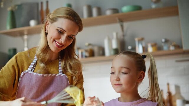 Smiling mother teaching daughter baking at kitchen closeup. Family making dough