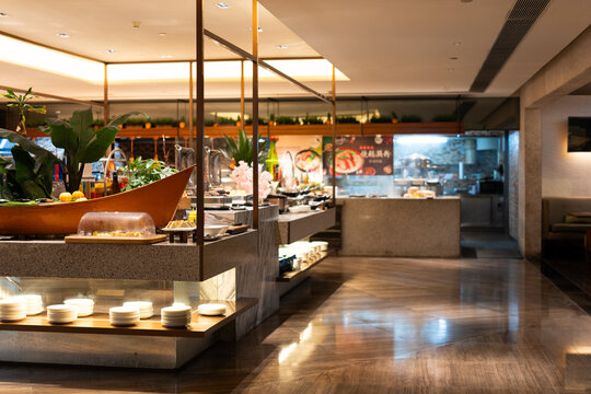 Modern buffet restaurant interior with glass display counters, polished floors, and Asian cuisine