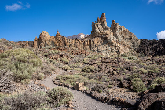 Mount Teide rising above the dramatic Roques de Garc&iacute;a, where ancient volcanic rocks meet a deep blue Tenerife sky.