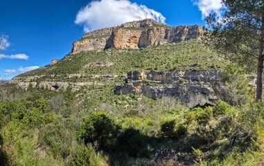 Fototapeta premium Montaña con formaciones rocosas en Cortes de Pallás, Valencia ,Paisaje de montaña con paredes rocosas en la Comunidad Valenciana, Sierra de Cortes de Pallás con formaciones geológicas y vegetación med