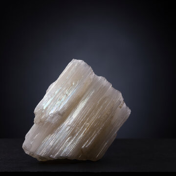 Sp&eacute;cimen de cristal de s&eacute;l&eacute;nite brut montrant une structure de croissance fibreuse parall&egrave;le longue, surface translucide blanc-cr&egrave;me au lustre soyeux