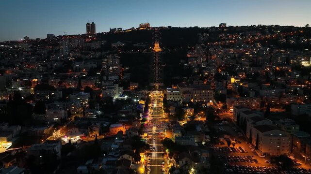 Aerial night view of Haifa with the Baha'i Gardens, German Colony, and the illuminated city port, Israel