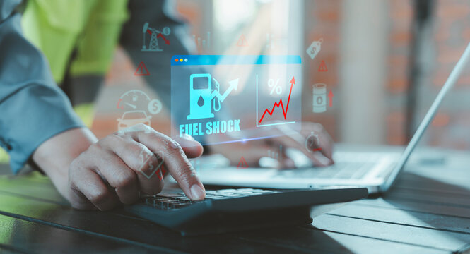 Logistics worker using calculator with fuel shock text and rising graph hologram for transportation budget planning, economic impact, energy crisis, commercial transport cost, fleet management