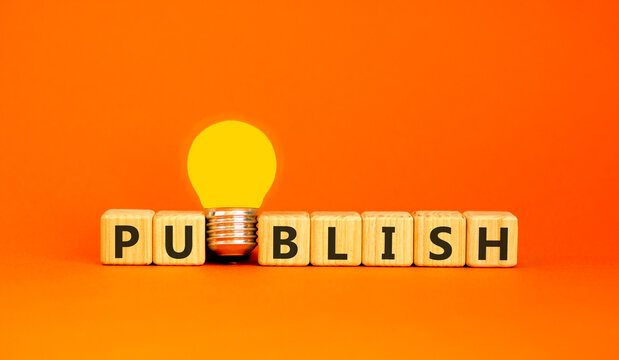 Publish word symbol. Concept word Publish on beautiful wooden blocks. Beautiful orange background. Beautiful yellow light bulb. Business publish word concept. Copy space.