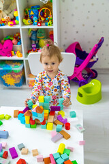 Fototapeta premium The child plays with toys in the room. Selective focus.