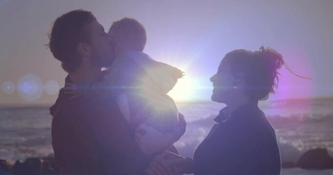 Father arriving with baby triggers mother sharing kiss with animated flares over sunset for health