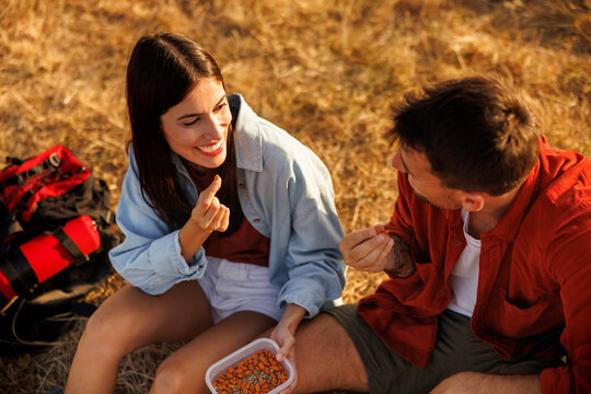 Couple having healthy snack while taking a hiking break