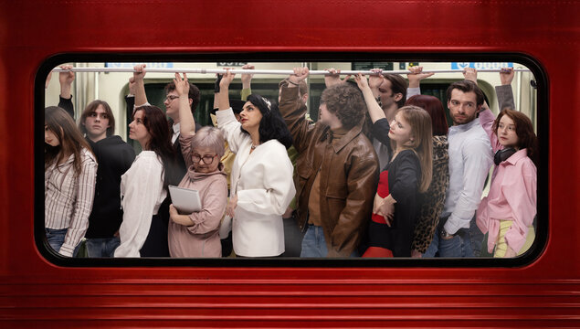 Diverse passengers standing inside subway train holding rail in red carriage in urban setting. Concept of daily commute, city lifestyle, public transport and social diversity.