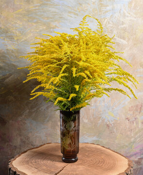Goldenrod Bouquet in Carved Glass Vase on Wood Slice