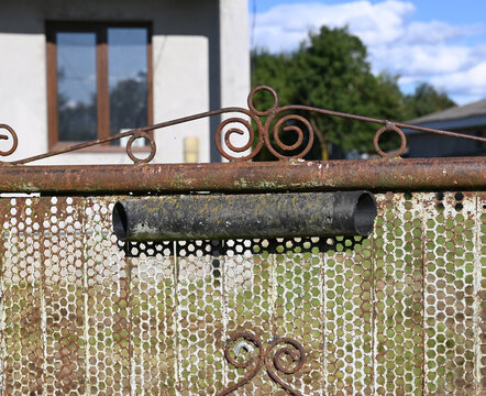 Weathered Metal Fence with Hexagonal Mesh and Wrought Iron Details