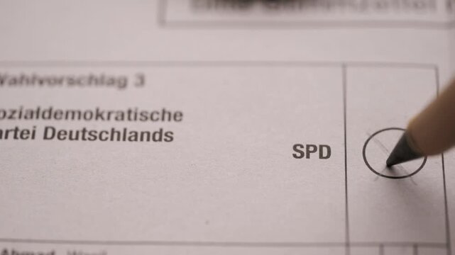 Voter marking cross in ballot circle for SPD party during election in Germany, democratic voting process, citizen participation in politics, social democratic choice and civic responsibility