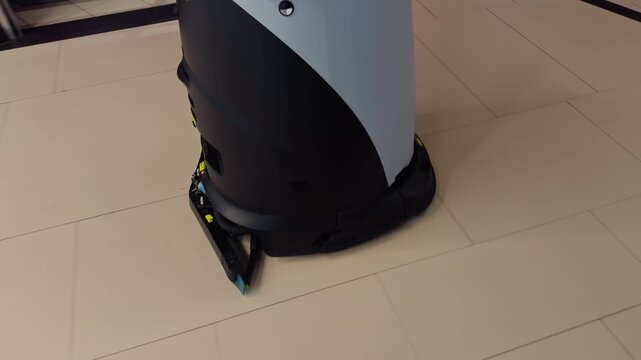 Autonomous robot navigating airport tiles with sensors. Floor cleaning robot equipped with lidar mapping in airport environment