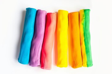 Naklejka premium Five rainbow colored play dough cylinders isolated on white background in top view
