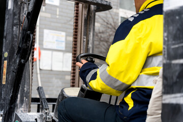 Worker operating a forklift in an industrial warehouse setting with close-up detail © zhu difeng
