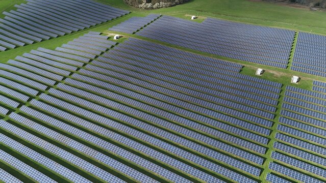 Aerial view of rows of solar panels stretch across the verdant landscape, reflecting the sky's light, a testament to renewable energy, Mansfield, England, United Kingdom.