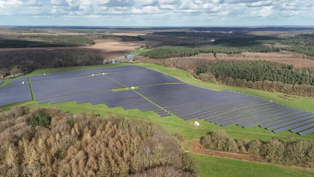 Aerial view of a vast solar farm basking in the sunlight, a modern power source contrasting with the surrounding natural landscape, Mansfield, England, United Kingdom.