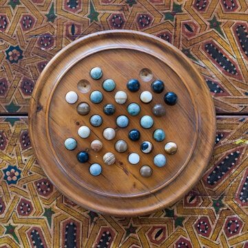 Fes, Morocco    Wooden marble solitaire board game on patterned Moroccan table