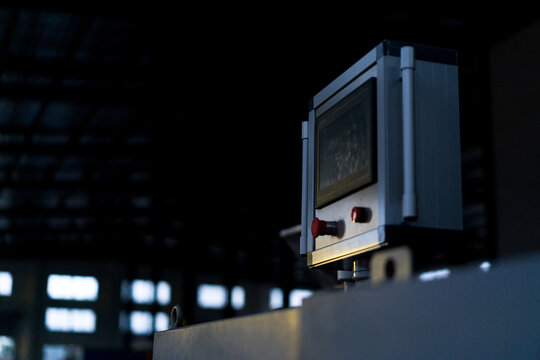 Close-up of an industrial control panel with display screen and operational buttons