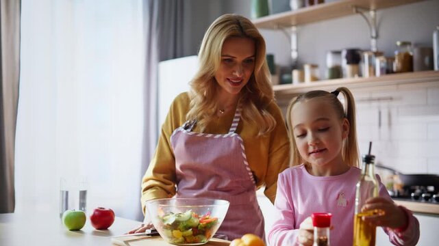 Small girl pouring oil adding species helping mother at home cuisine closeup