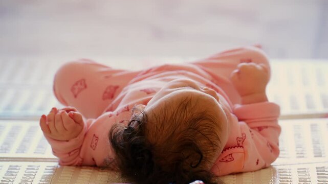Baby lying on a play mat surrounded by colorful toys during playtime