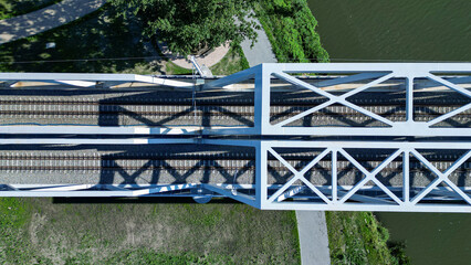 Fototapeta premium A modern iron railway bridge on a sunny day, seen from above