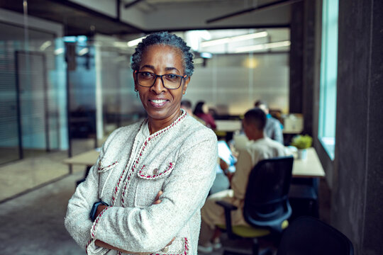 Confident senior businesswoman leading team in modern office