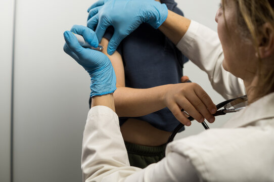 Focus on the injector pen interface as a medical professional applies a dose to a patient's arm.