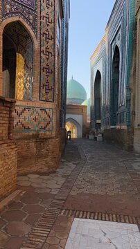 Golden morning in Shah-i-Zinda necropolis. Magnificent tiled mausoleums - brilliant blue, turquoise mosaics, arches glow, azure dome mosque in soft sun. Majestic heritage Samarkand, Uzbekistan.