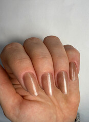 Beige cat eye gel polish on almond nails, glossy shimmer manicure