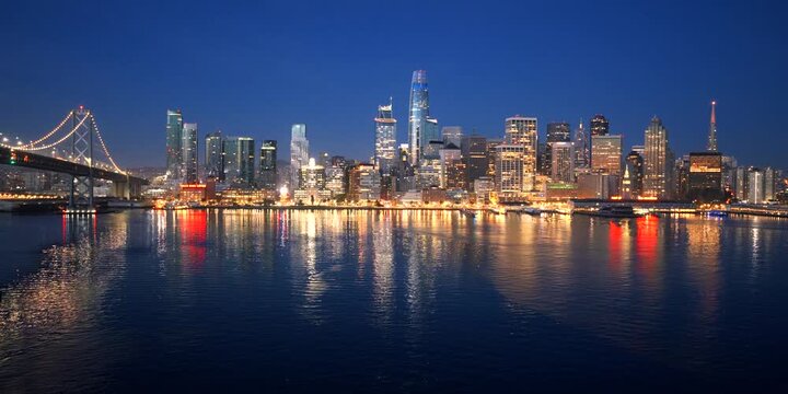 San Francisco - Epic Shot of Downtown SF Skyline Over Bay with City Lights Reflecting on Bay from Low Aerial Angle