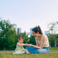 Fototapeta premium Happy Asian Mother and Toddler Daughter Outdoor Family Bonding Lifestyle in Park.