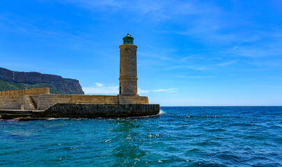 Le phare de Cassis avec en arrière-plan la falaise et un ciel bleu au-dessus d'une mer turquoise, Var, Provence, France © William Vallée
