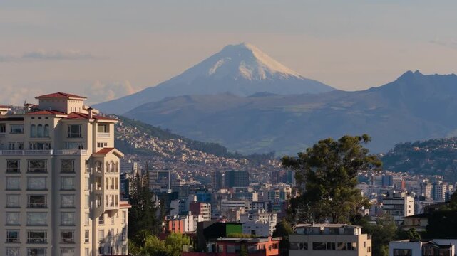 Aerial drone view of Quito skyline with the snow capped Cotopaxi volcano rising above the Andes mountains in the distance. 