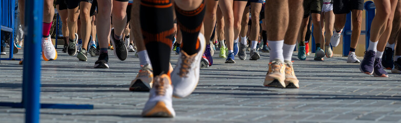 Front view of marathon runners feet crossing promenade during organized race © JairoMZ
