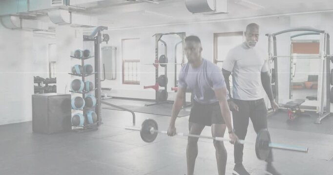 Trainee gripping barbell, doing hip-hinge deadlifts for training, coach with tablet correcting form