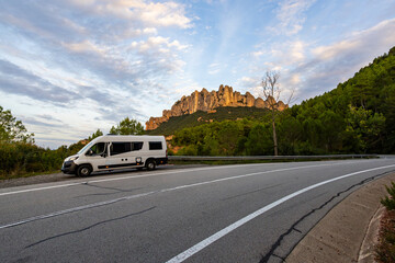 Fototapeta premium Campervan parked on road traveling through Montserrat mountains